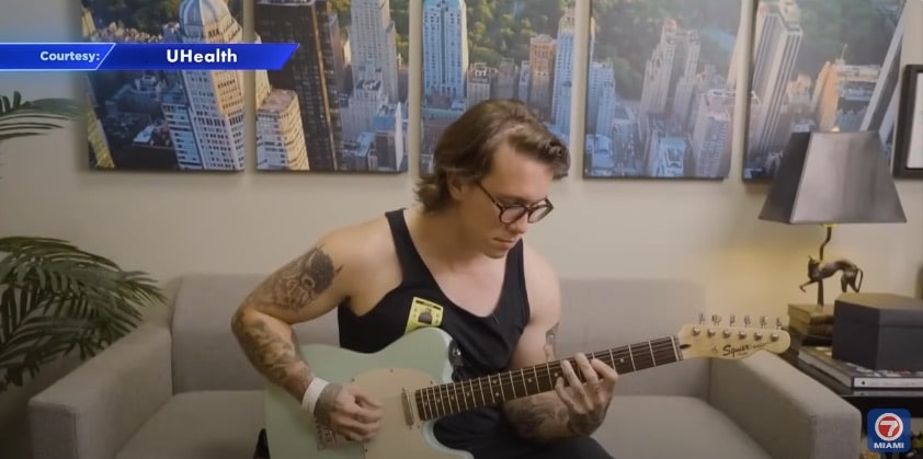Professional guitar player Christian Nolen plays his guitar after his brain surgery
