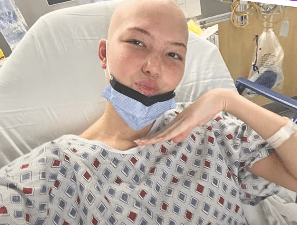Isabella poses for photo in her hospital bed in YouTube video.