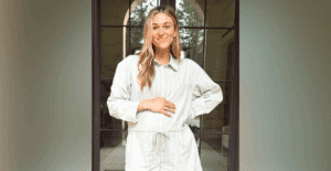 Pregnant Sadie Robertson smiles while cradling her baby bump