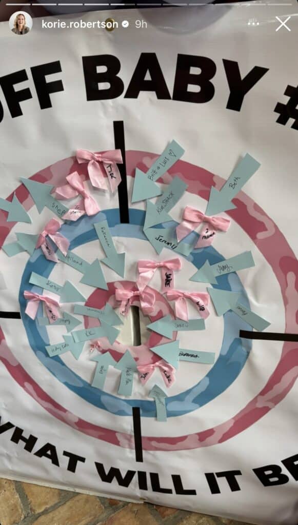 Guests at the gender reveal put their predictions on a target: pink bow for girl, or blue arrow for boy