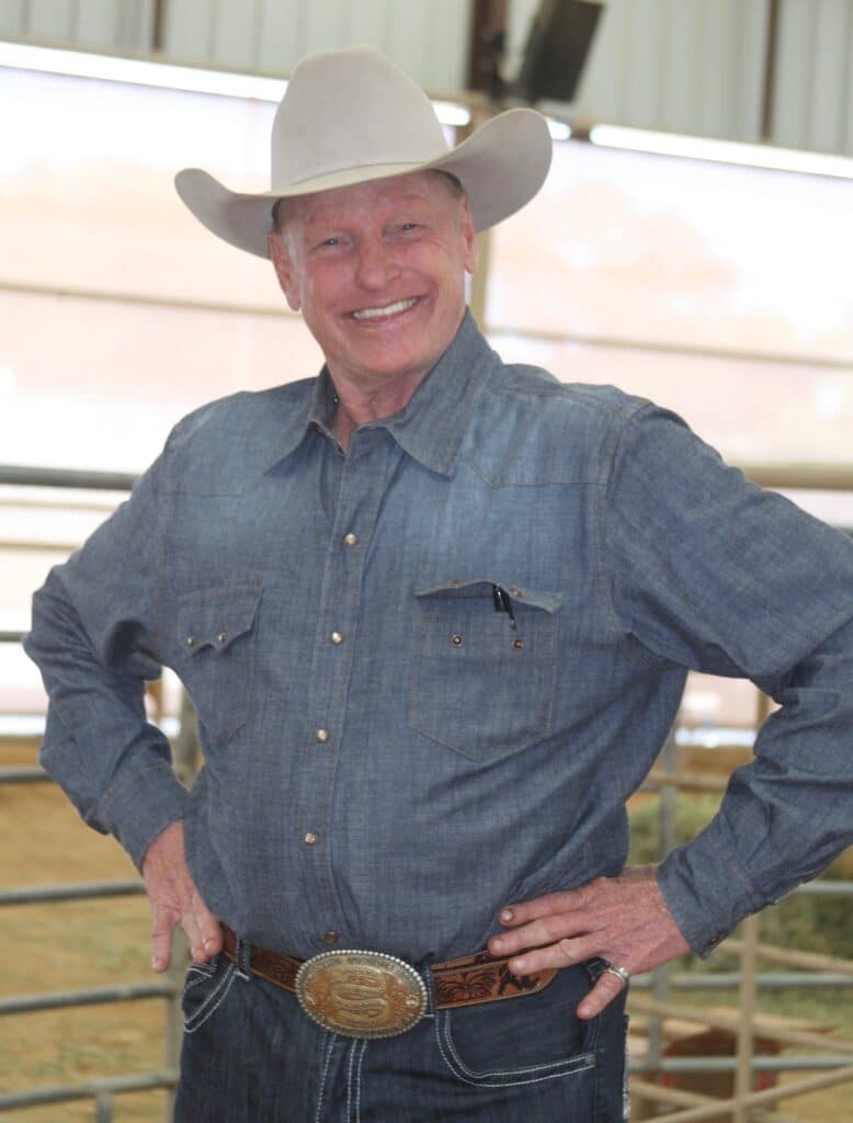 Rodeo legend Roy Cooper stands with his hands on his hips
