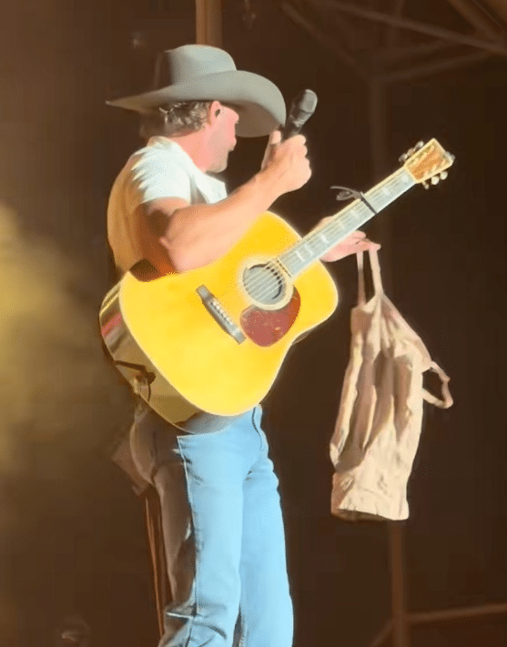 Riley Green holds up Spanx that was thrown on stage. 