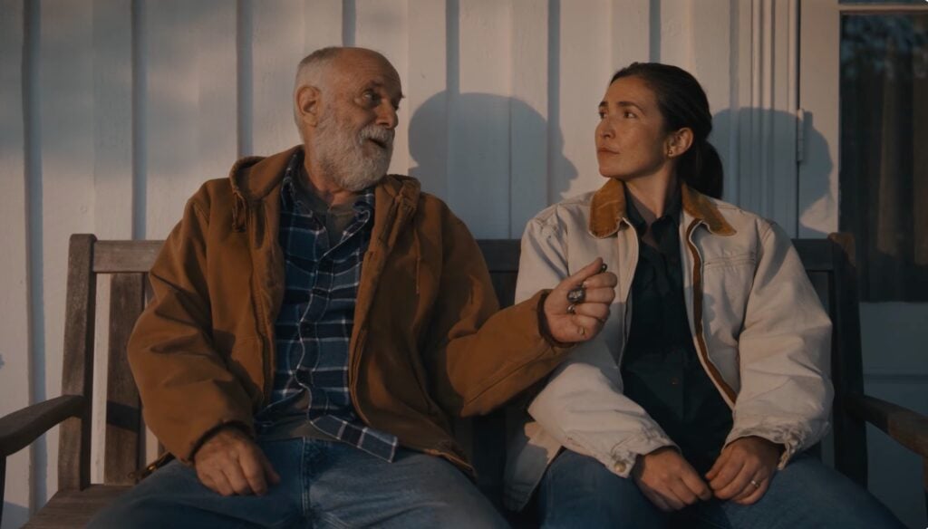 father and daughter sit on porch 
